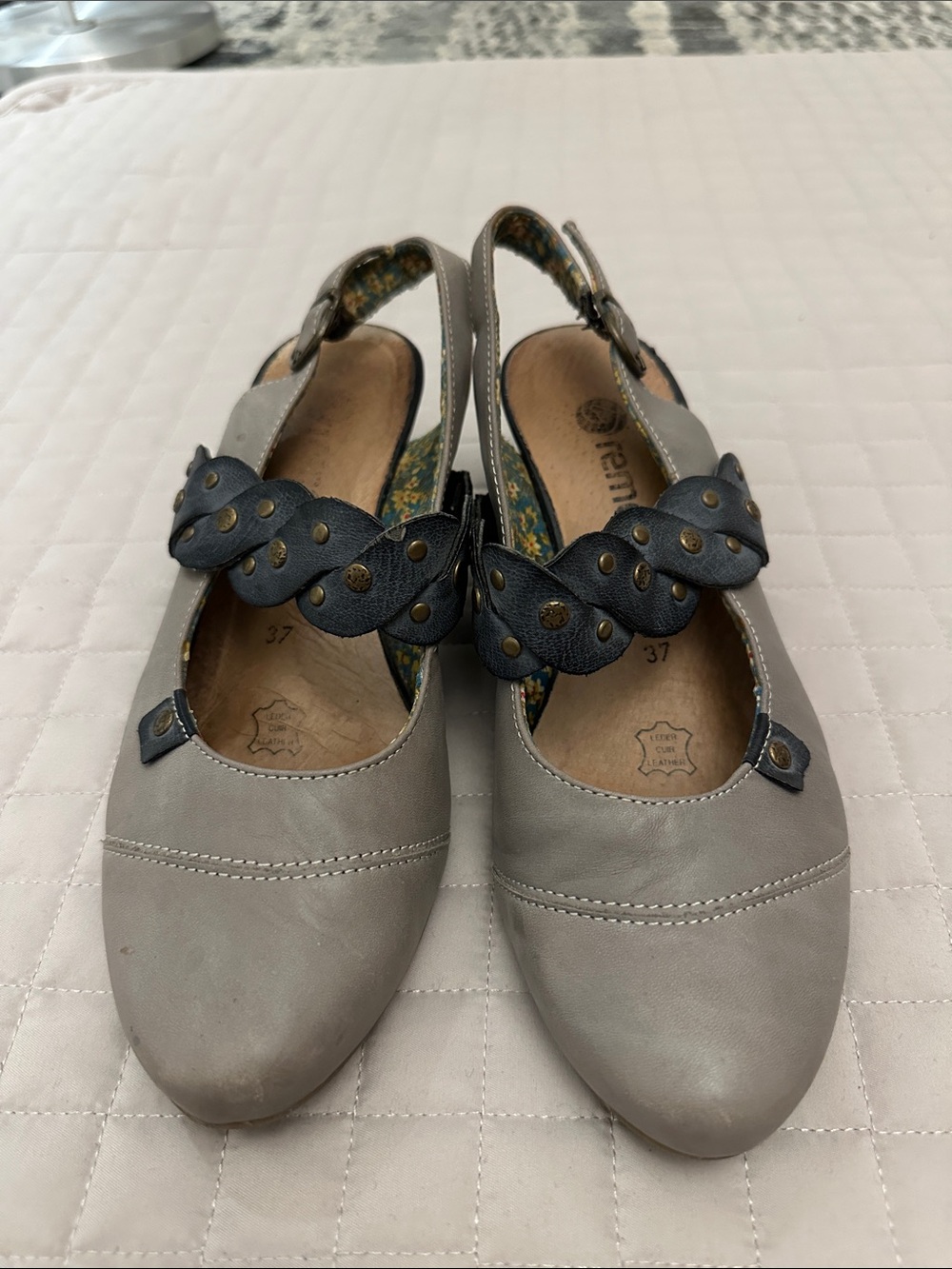 Rieker grey leather shoes with braided strap detail and floral lining.